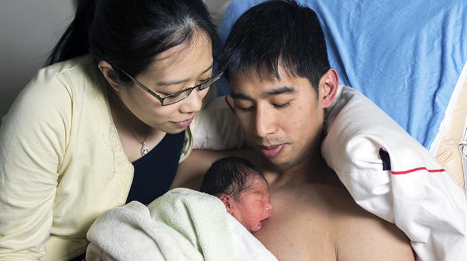 Parents holding baby skin-to-skin